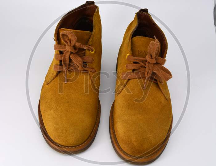 Casual, universal ordinary shoes for a daily walk. Brown half boots, shoes on a wide beige cachic sole. Footwear made of genuine leather, natural suede with brown wide shoelaces.