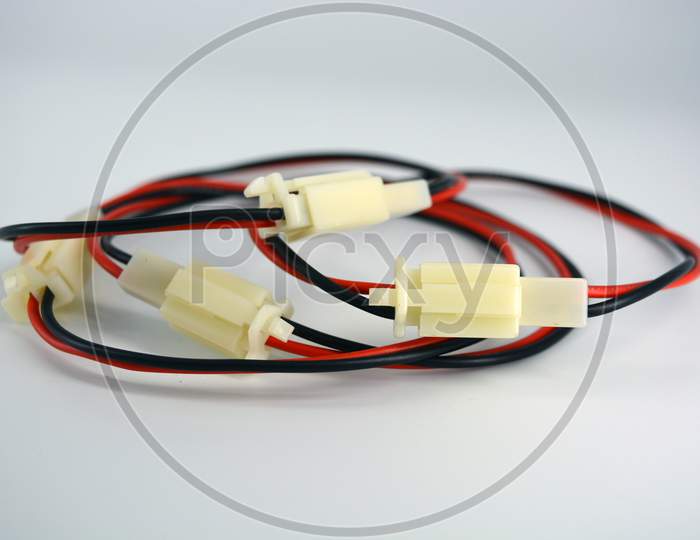 Large electric red black wires on 12V, 220V with white plastic dad connector and mom located on a white plastic background.