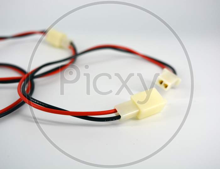 Large electric red black wires on 12V, 220V with white plastic dad connector and mom located on a white plastic background.