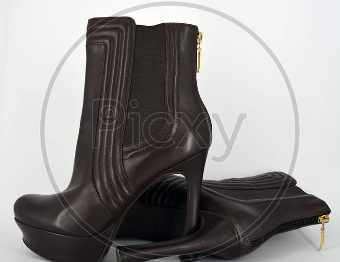 Brown sexy stylish female autumn boots with a wide gum from a natural smooth. Women's shoes on a high thin hairpin, a wide platform with a zipper on the heel located on a white background.