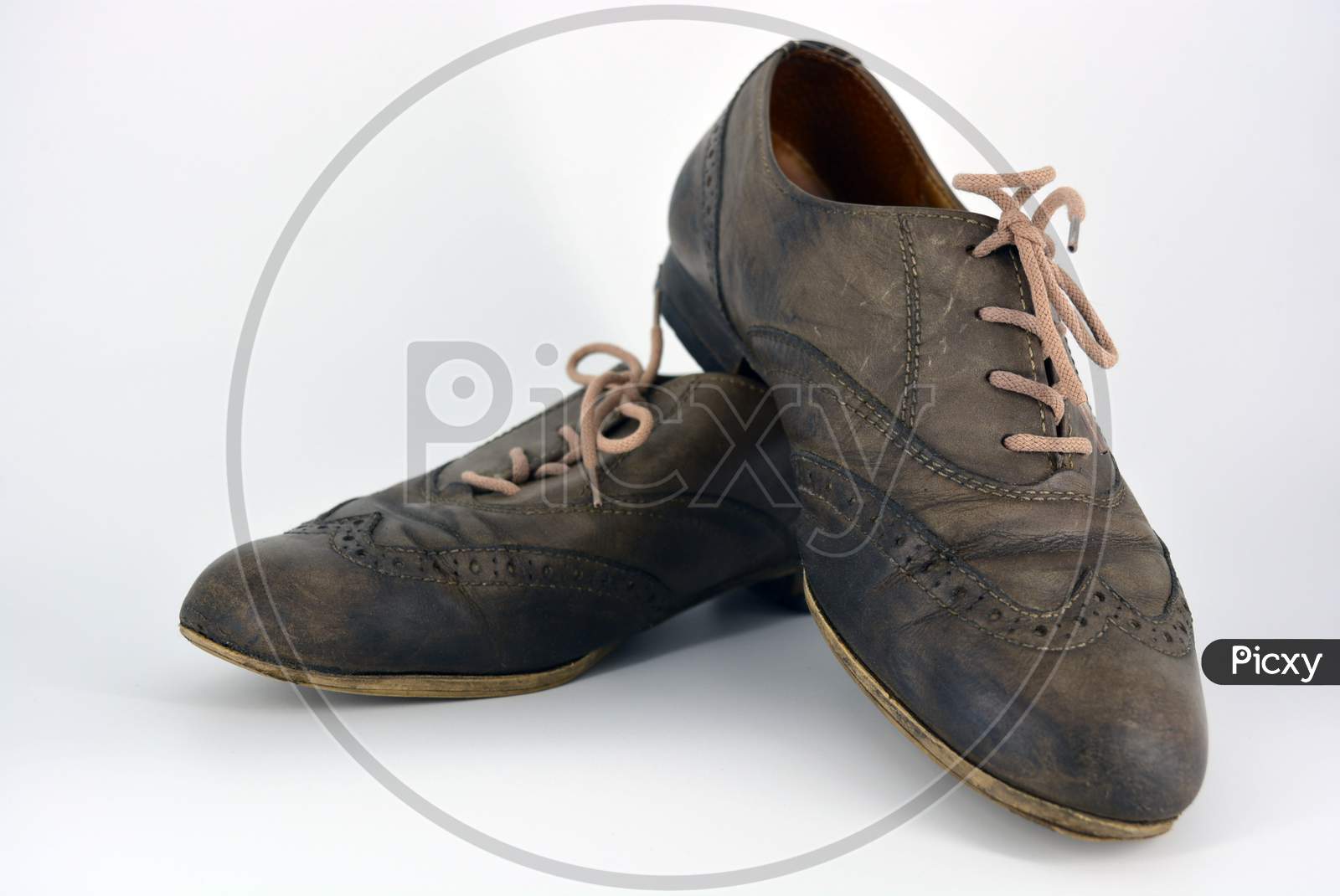 Female leather shoes located on a white background. Oxford shoes with gray shoelaces on a flat heel. Gray women's shoes in a fastening, unwitting.