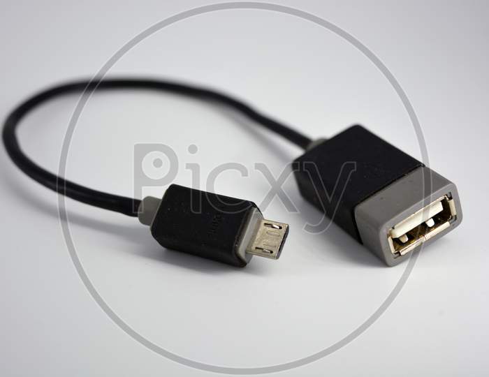 Adapter black wire for computer and phone is located on a white plastic background.
