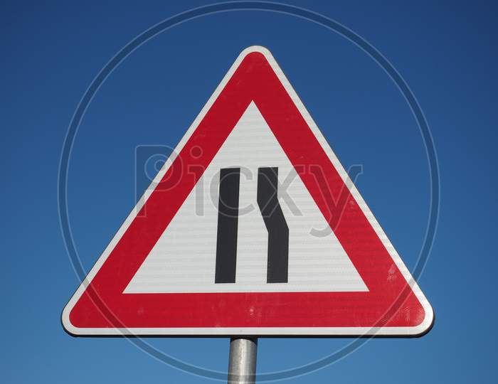 Road Narrows Sign Over Blue Sky