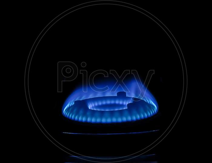 Stock Photo Of Gas Burner With Blue Flame On Kitchen Stove In Dark Black Background, Focus On Object.