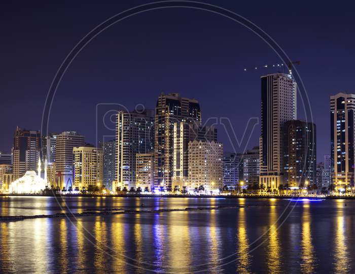 Sharjah,Uae,Dec 2Nd 2020. Panoramic View Of The Illuminated Sky Scrappers Along With The Famous Al Noor Mosque Showing Beautiful Reflections In Water Captured At The Al Majaz Waterfront Sharjah , Uae.