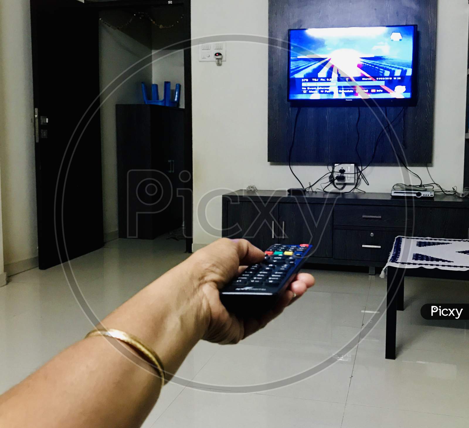 Hand using remote control for changing television channel