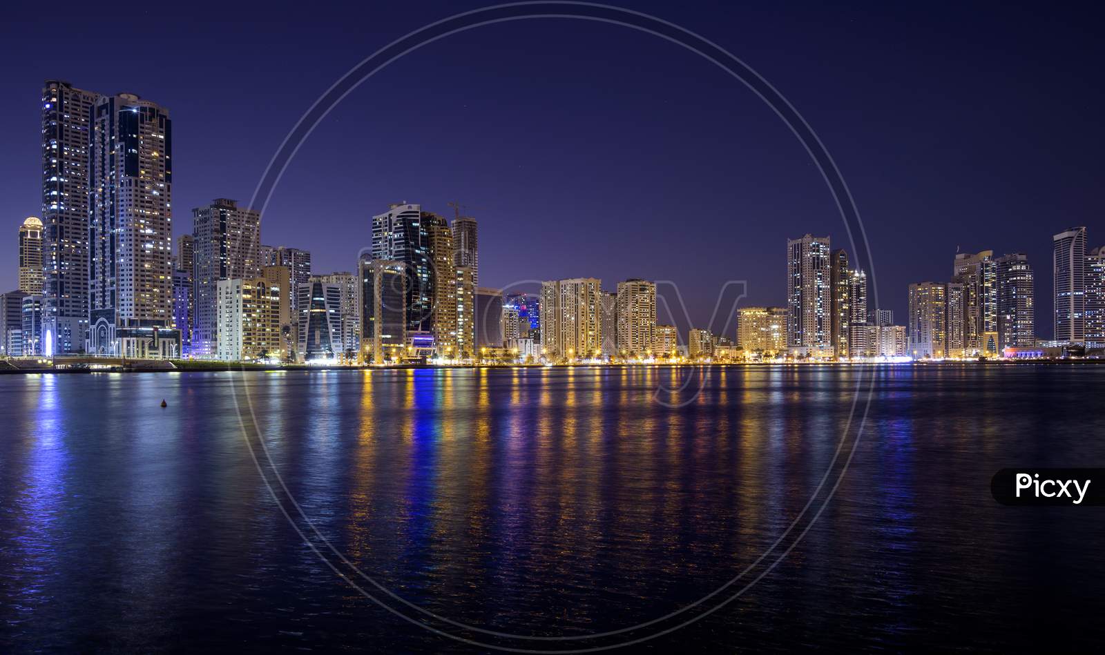 Sharjah,Uae - Dec 2Nd 2020. Panoramic View Of The Illuminated Sky Scrappers Showing Beautiful Reflections In Water Captured At The Al Majaz Waterfront Sharjah , Uae.