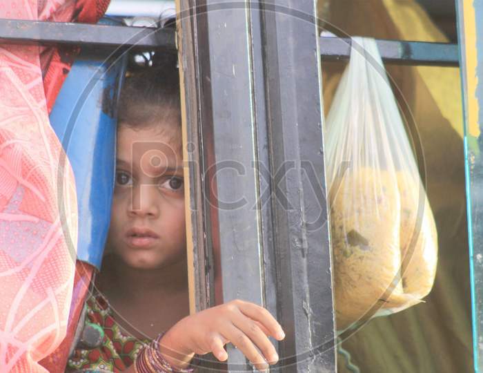 Food Security Gets Grave: A Baby Girl Peeps Out Of The Bus After Collecting Food For The Family From The Shrine Of Bari Imam In Islamabad.