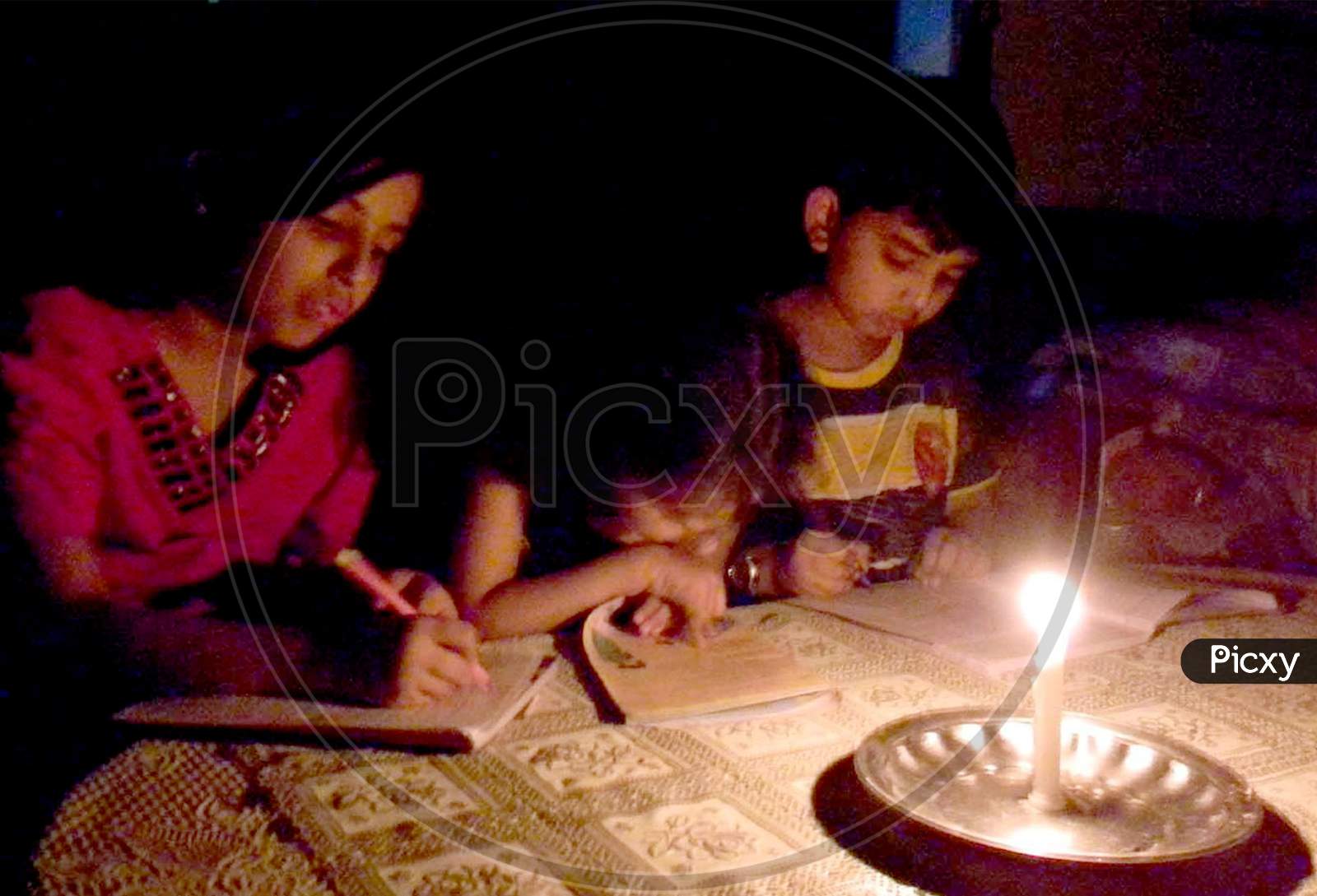 students are busy in study on candle light