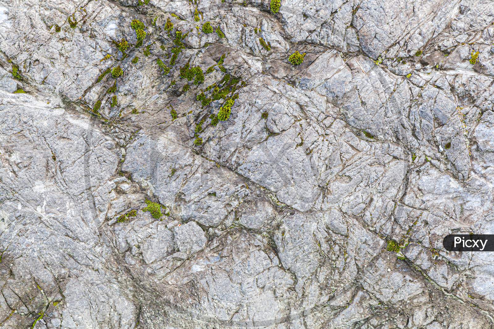 Close-Up Of A   Gray Stone Wall Of A Very Old Mountains.  Gray Texture Background. Close-Up Rock Formation.