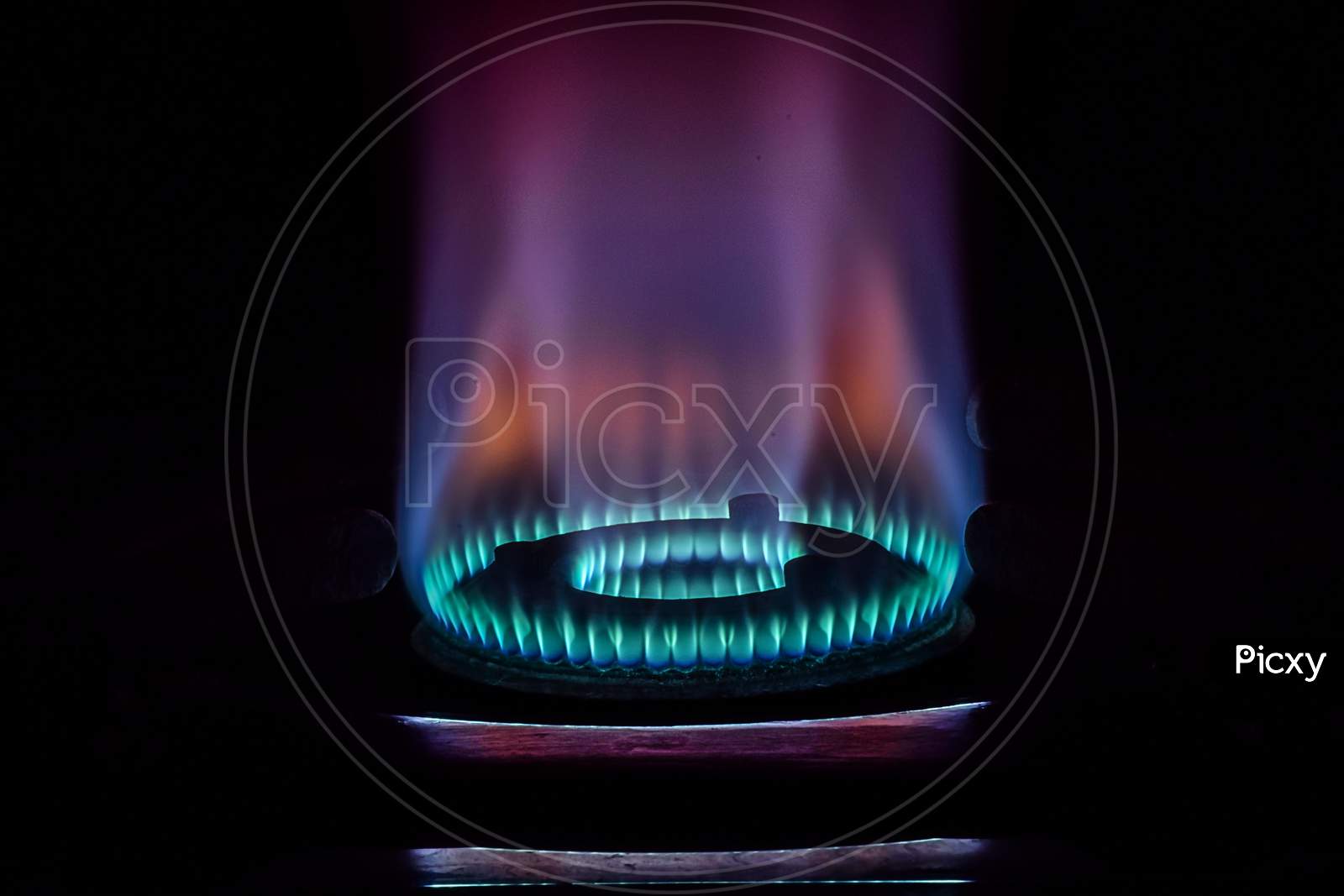 Stock Photo Of Gas Burner With Blue And Purple Flame On Kitchen Stove In Dark Black Background, Focus On Object.