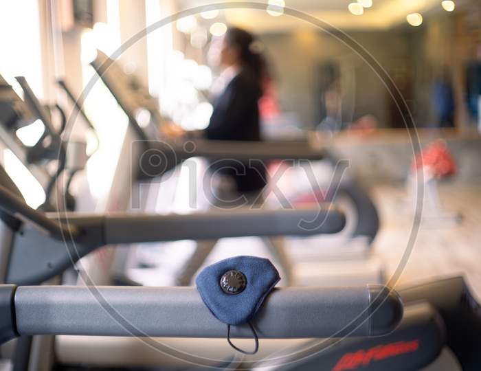 Shallow Depth Of Field Shot With A Face Mask To Prevent Infections Like Covid 19 Pandemic From Spreading On A Treadmill As People Excercise To Build Immunity And Recover From The Long Term Effects Of The Coronavirus Infection During Rehabilitation Physiotheraphy