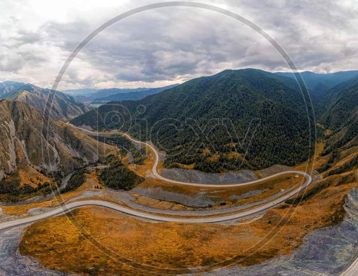 Stunning Landscape Of High Mountains, Highway, Coniferous Forest On An Autumn Day. Photographing Mountains With A Quadrocopter