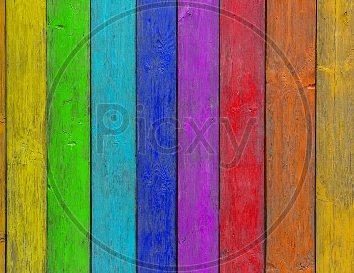 Close-Up Of A   Rainbow Wooden  Wall  Or Fence Painted A Very Long Time And The Paint Peeled Off.  Fun Background For Kids Decor And Design.