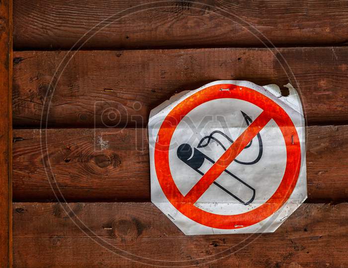 Close-Up Of A  No Smoking Sign On Brown Wooden  Wall .  The Concept Of Prohibition And Smoking Cessation