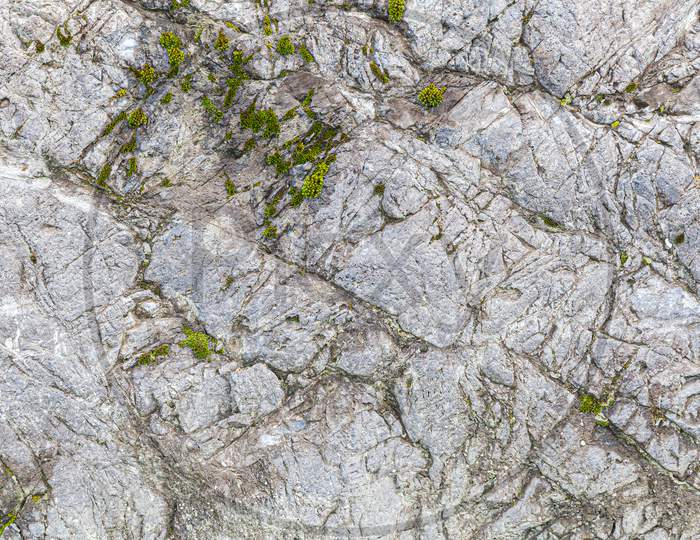 Close-Up Of A   Gray Stone Wall Of A Very Old Mountains.  Gray Texture Background. Close-Up Rock Formation.