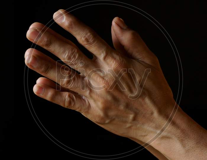 Praying Hands Of An Old Indian Catholic Woman Isolated On A Plain Black Background.