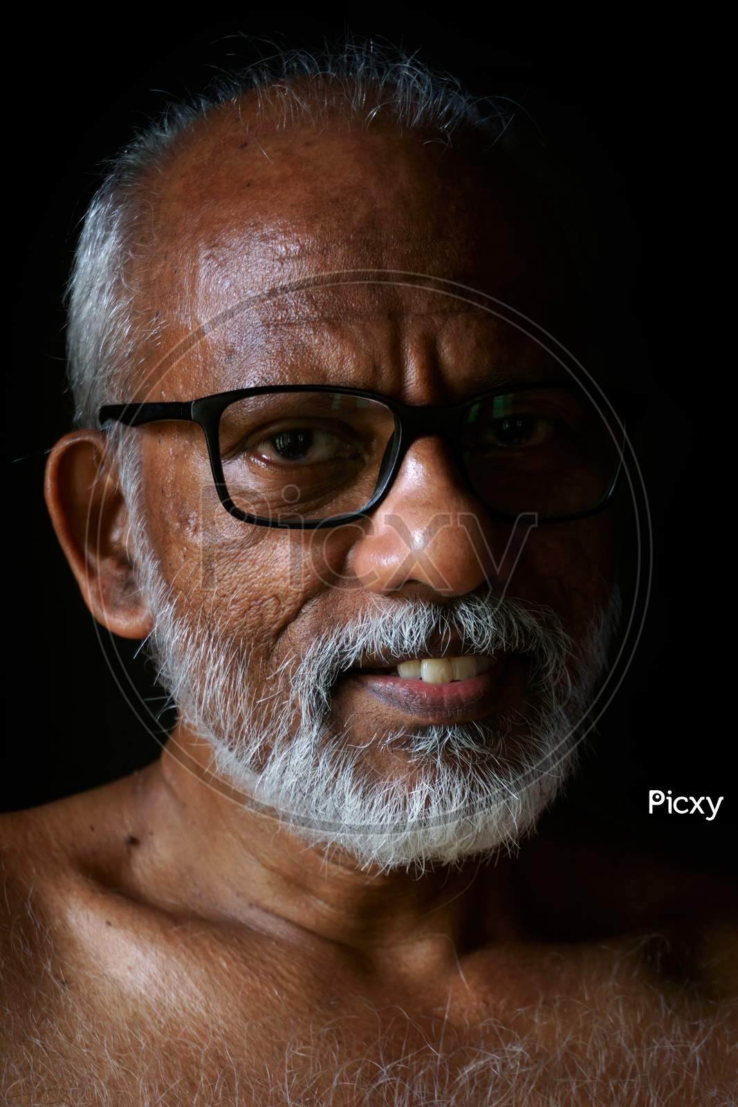 Closeup Portrait Of A Smiling 60-Year-Old Malayali Man.
