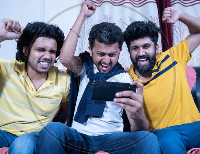 Three Friends Shouting And Creaming While Watching Live Streaming Sports On Mobile Phone - Concept Of Sport Fans Support And Enjoyment.