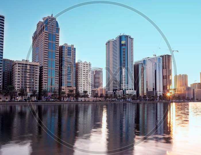 Sharjah,Uae - Jan 9Th 2021. Panoramic View Of The Sharjah Sky Scrapers Showing Beautiful Reflections In Water Captured During Early Morning Sunrise Time From Al Noor Island Sharjah , Uae.