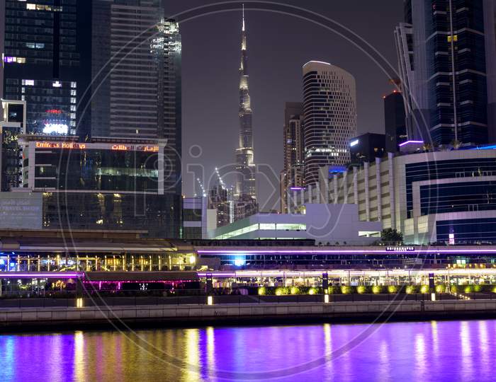 Dubai, Uae 6Th Nov 2020 -View Of The Burj Khalifa Surrounded With Buildings And Hotels Facing The Colorful Illuminated Dubai Canal Boardwalk Waterfall In Dubai,United Arab Emirates, Middle East