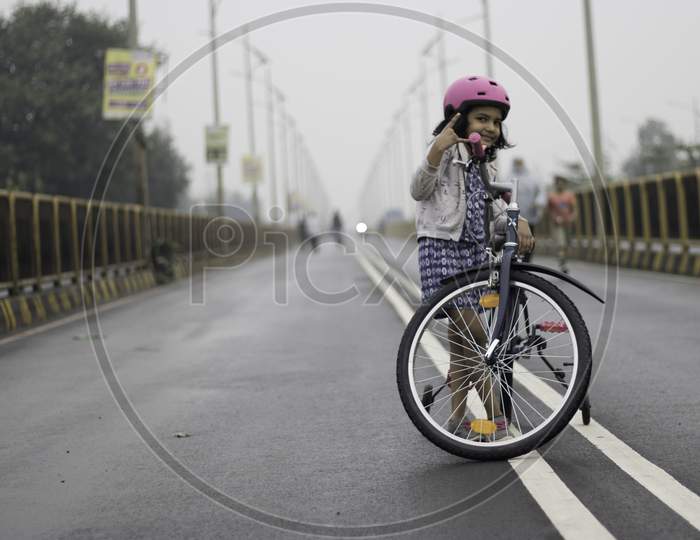 Little girl with bicycle on street