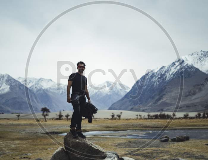 Young Indian Tourist Posing On The High Mountain Rock In Ladakh
