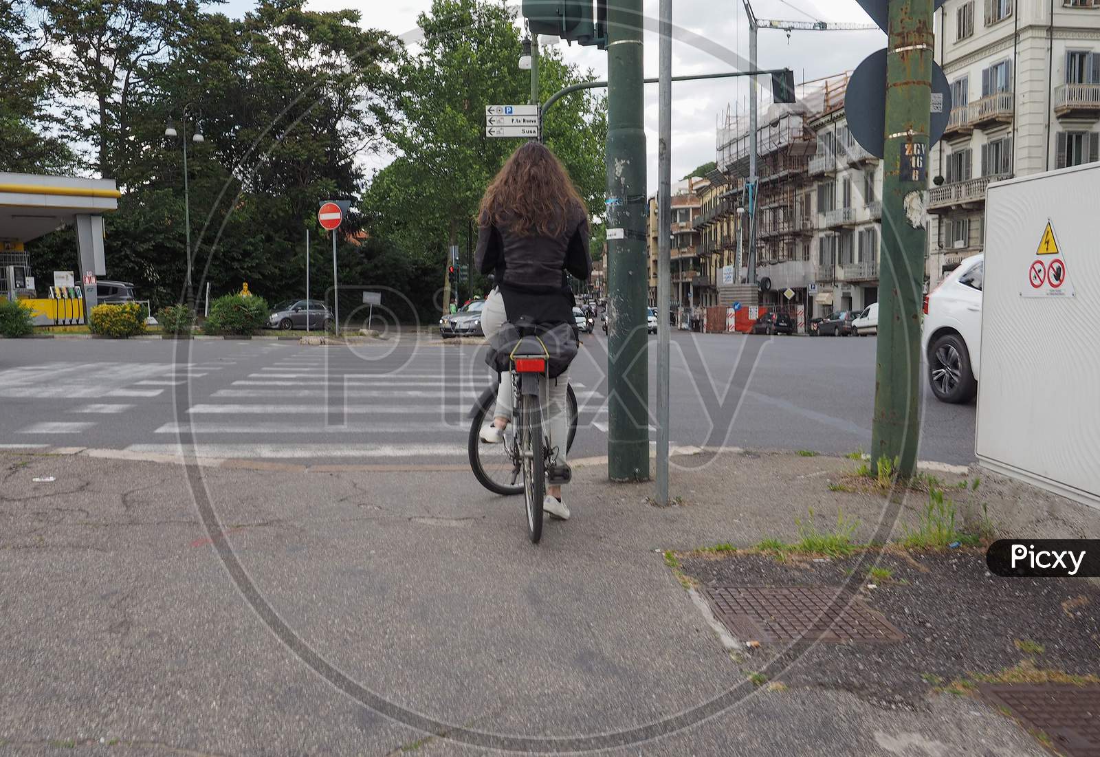 Turin, Italy - Circa May 2019: Woman On A Bike At Traffic Light Zebra Crossing