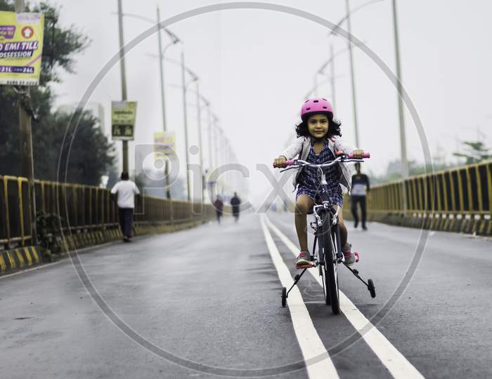 Little girl with bicycle on street