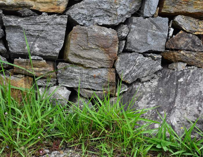 Walls Of Natural Stone With Green Grass