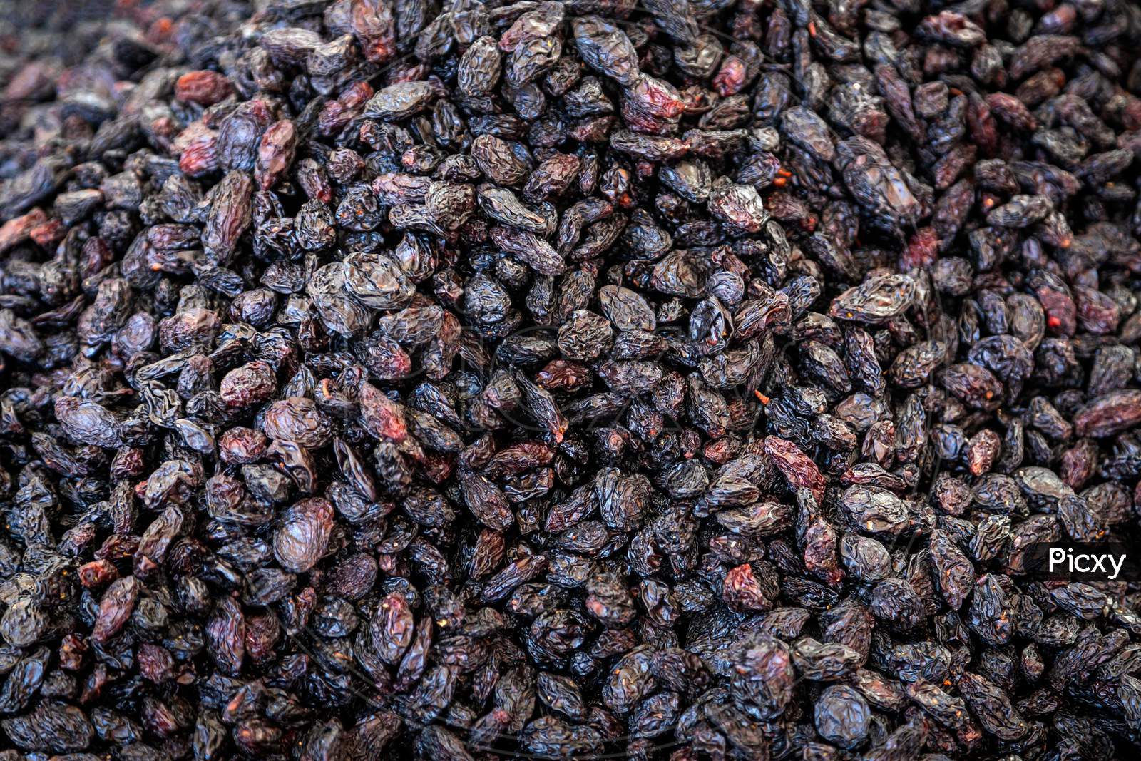 Close-Up Of Purple Raisins On A Showcase In A Supermarket, Top View. Dried Grapes