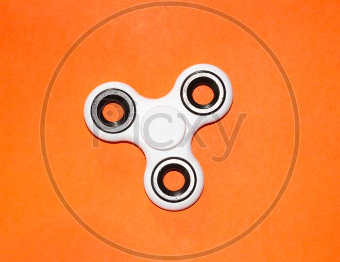 finger spinner toy on orange background