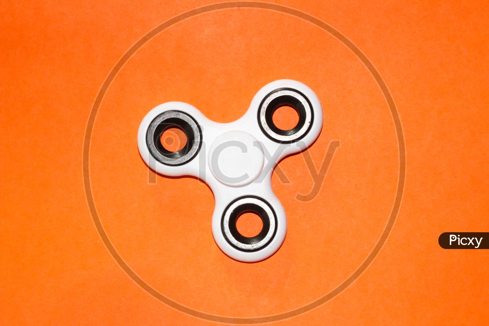 finger spinner toy on orange background