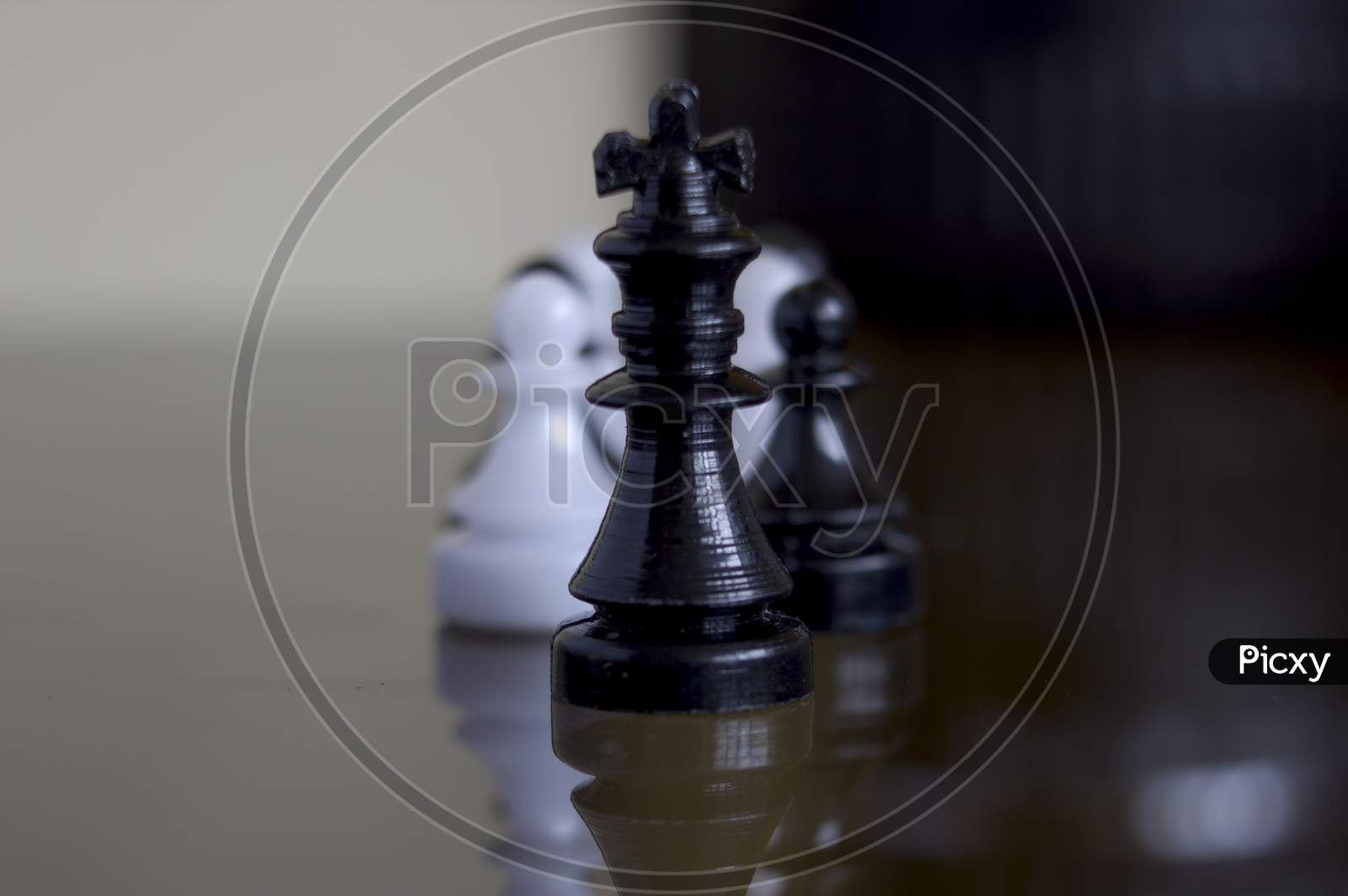 Extreme Close Up Macro Shot Of A Black Chess King Standing In Front Of Black And White Pawns Showing Leadership Concept. Selective Focus.