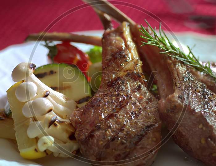 Organic Grilled Lamb Chops with  bake white mushroomand tomatoes.