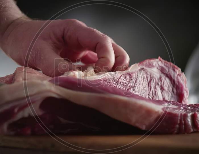 Closeup Shot of Butcher hand cutting meat on kitchen