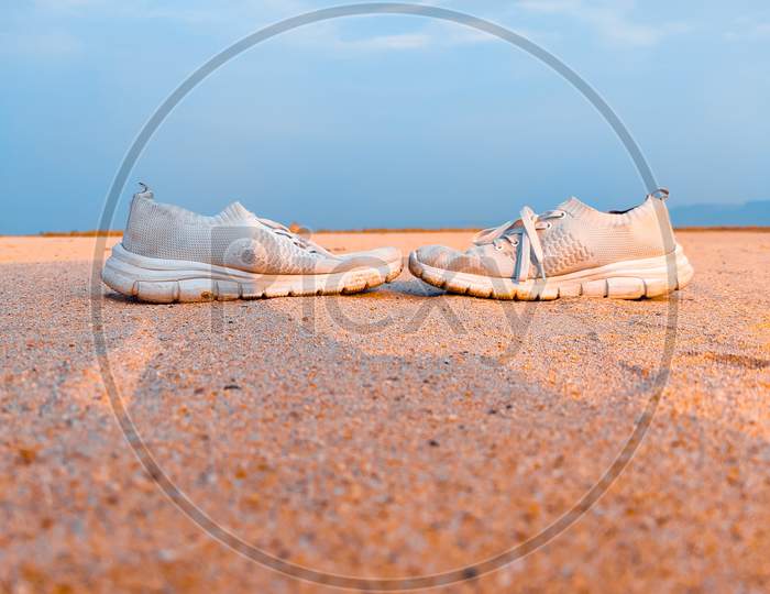 A White Shoes In Sand Desert Land