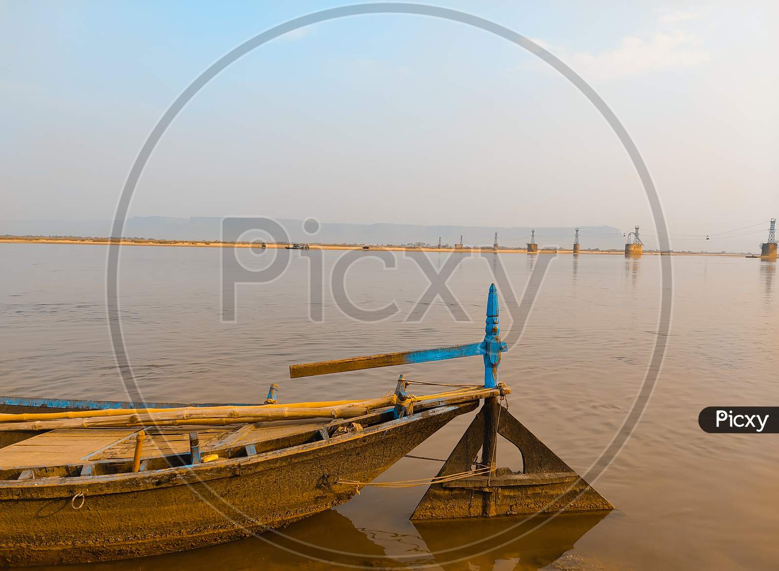Boat In River With Light Yellow Blue Sky Background.