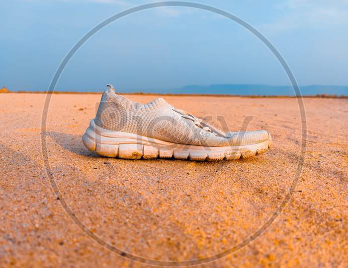 A White Shoes In Sand Desert