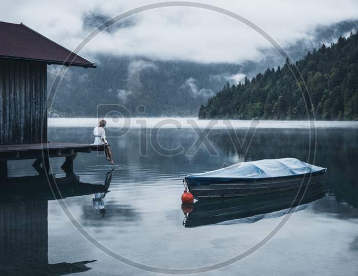 A Man Sitting Near A Lake And A Boat, Asthetic View