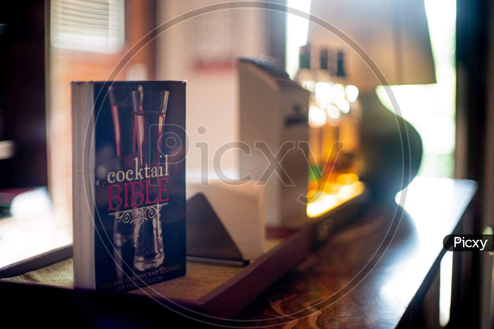Cocktail Bible Book Guide Kept At The Counter Of A Bar Pub In India With Out Of Focus Bottles In The Background Showing The Rising Interest Of Liqor In India
