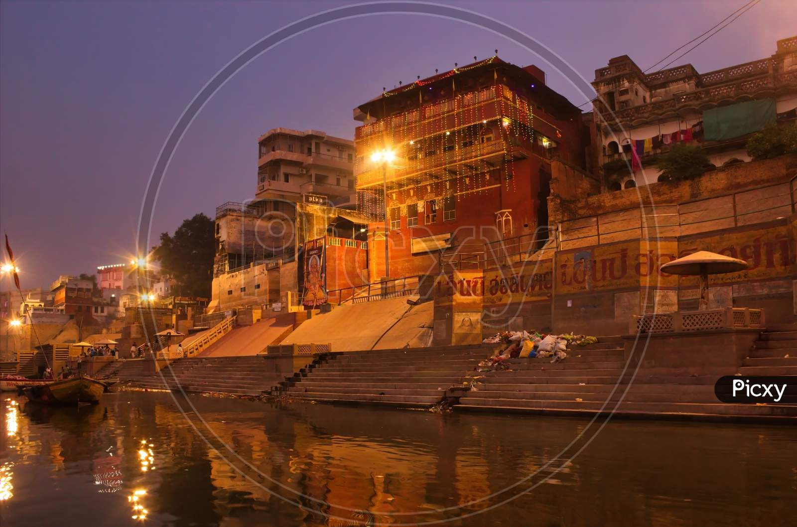 India, Varanasi Ganges River Ghat With Ancient City Architecture As Viewed From A Boat On The River At Morning Time.
