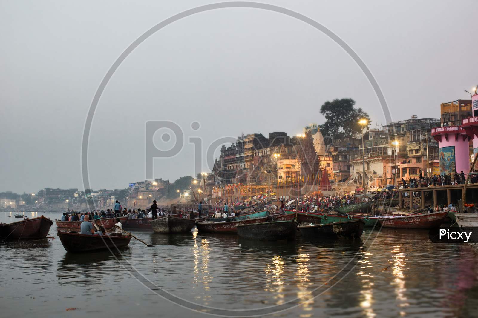 Varanasi, India - November 01, 2016: Boats At River Ganga Ghat People At Holy Ghats Among Ancient Hindu Temples In Early Morning In Varanasi Or Ancient Banaras City India Assi Ghat Aarti Ceremony At Ganga River Evening At Banaras Ghat Ancient Wooden Boats