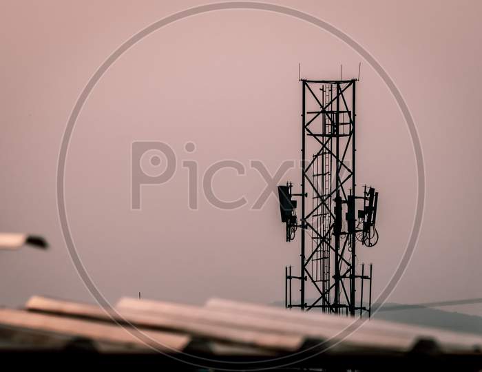Silhouette of Telecommunication tower of 4G and 5G cellular. Macro Base Station. Wireless Communication Antenna Transmitter. Telecommunication tower with antennas against sky and clouds background