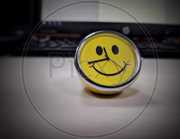 Hyderabad, India - May 06, 2021: Yellow Smiling Face Clock In The Office,Blurred Background.