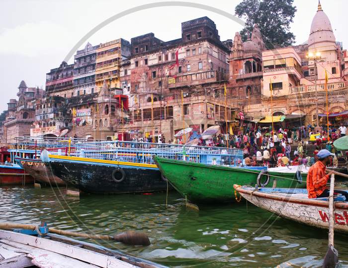 Varanasi, India - March 16, 2019: Bunch Of Wooden Boats At River Ganga Near Dashashwamedh Ghat In Morning. Ancient Architecture Of City In The State Of Uttar Pradesh.