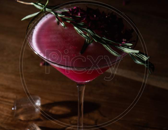 Red cocktail drink with rosemary dressing