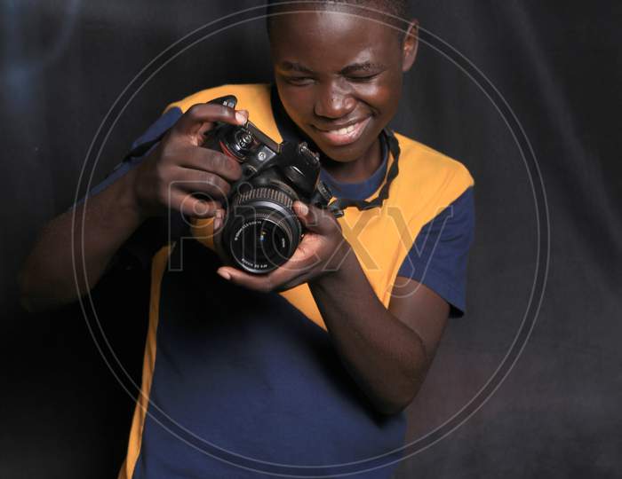 Black African American young man holding a camera in his hands  all the way from African