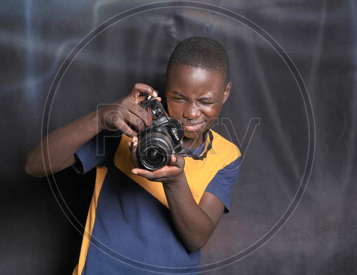 Black African American young man holding a camera in his hands  all the way from African