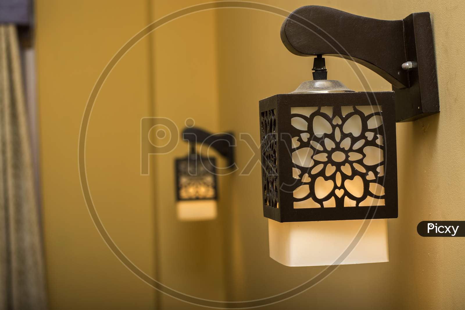 A Beautiful Lamp Shade On Wall And Another Lamp Shade On Background.